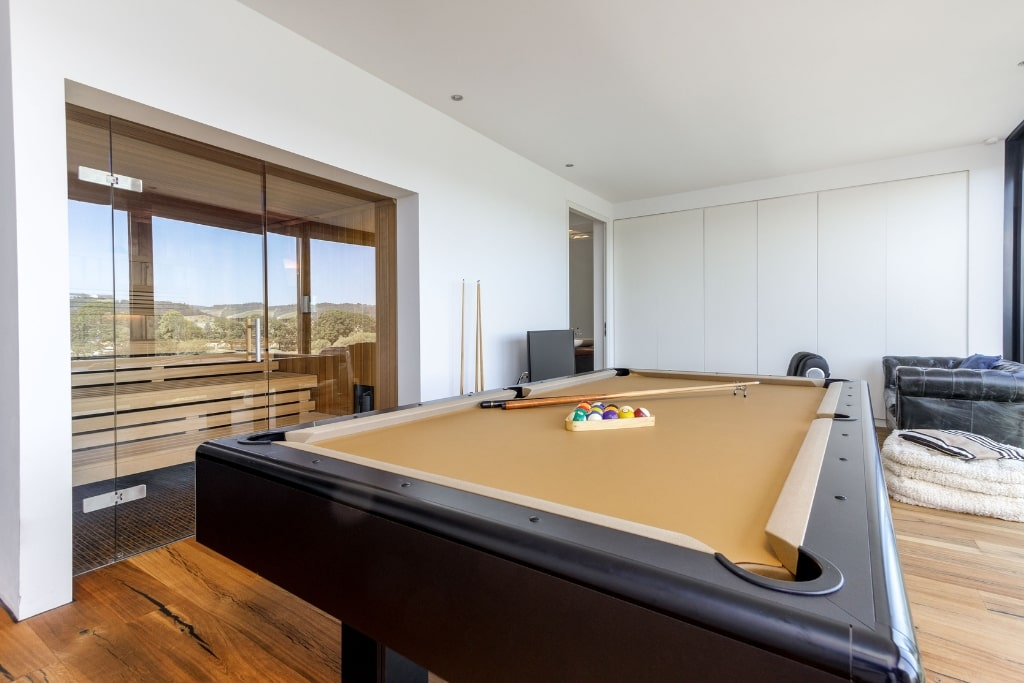 Der Wohnbereich eines Einfamilienhauses in Trier mit Billardtisch und dahinterliegender Sauna.
