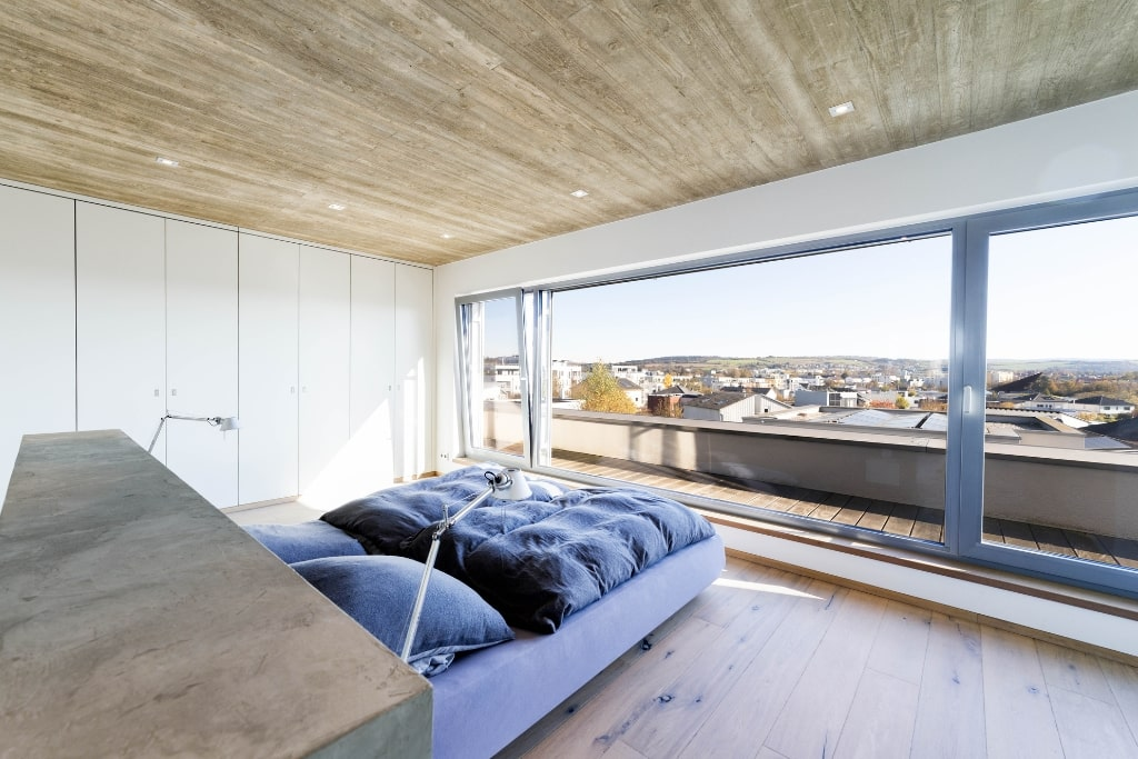 Das Schlafzimmer mit Panoramafenstern einer Luxusimmobilie auf dem Petrisberg in Trier.