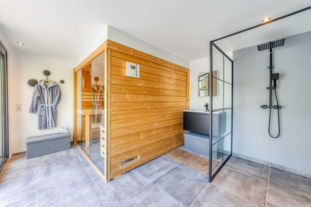 Ein modernes Badezimmer einer Luxusimmobilie in Trier mit integrierter Sauna.