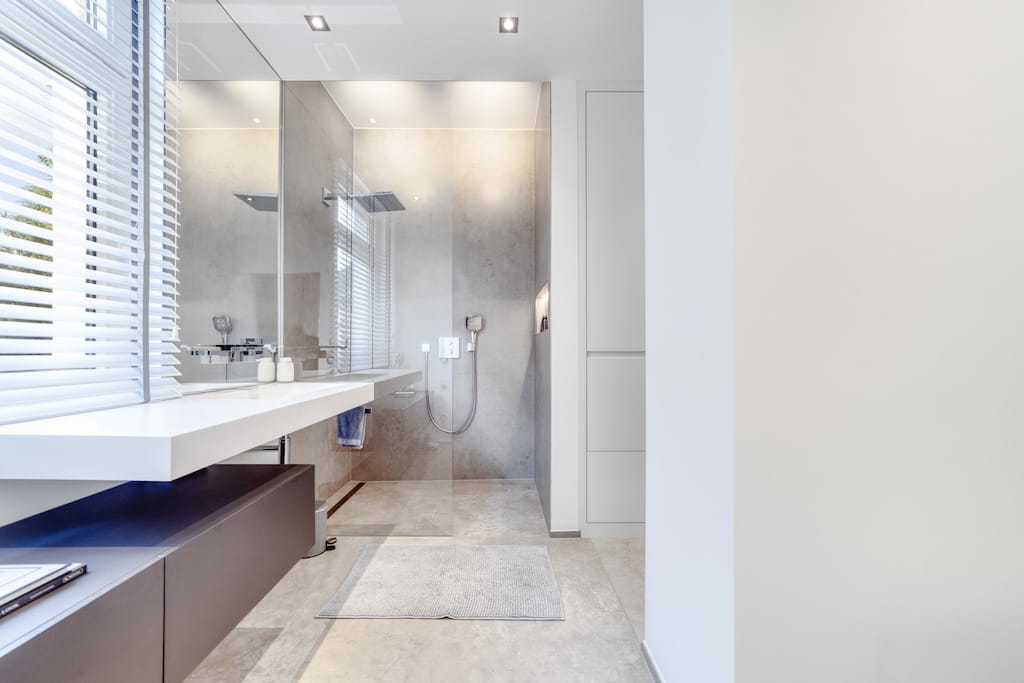 Das Badezimmer einer Luxusimmobilie in Trier mit bodengleicher Dusche.